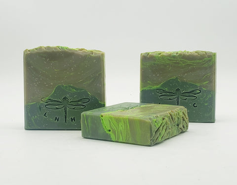 Handmade green soap bars with dragonfly imprints.