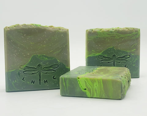 Handmade green soap bars with dragonfly imprints.