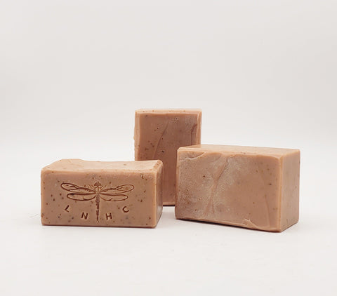 Pink handmade soap bars with dragonfly imprints.
