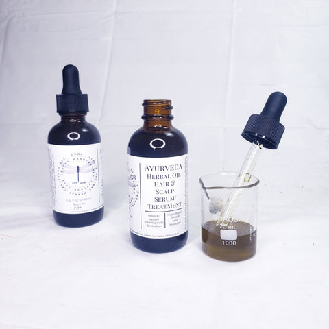 Two dark glass bottles of herbal hair and scalp treatment products with dropper caps.