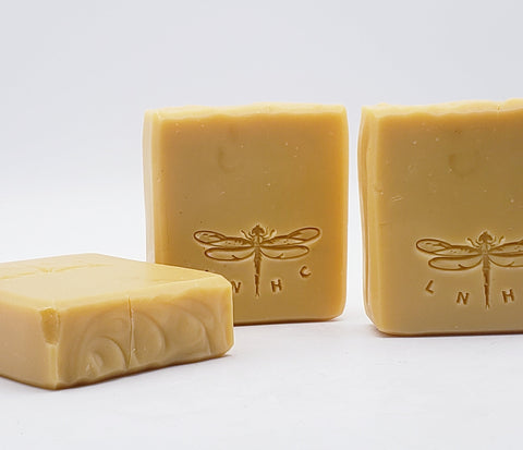 Handmade soap bars with dragonfly designs stamped on them.