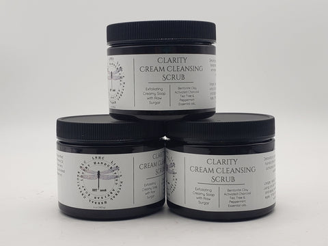 Jars of Clarity Cream Cleansing Scrub skincare product stacked in a pyramid formation.