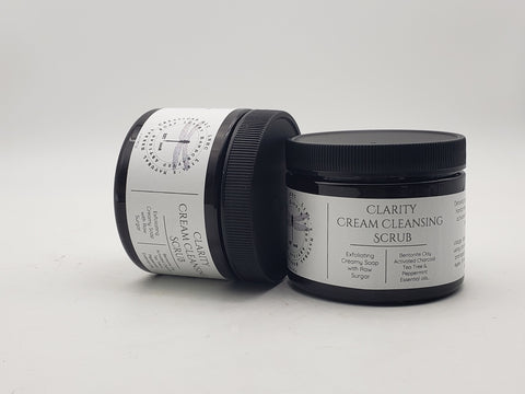 Jars of Clarity Cream Cleansing Scrub skincare product stacked in a pyramid formation.