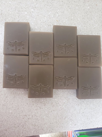 Bars of handmade soap with dragonfly designs stamped on them.