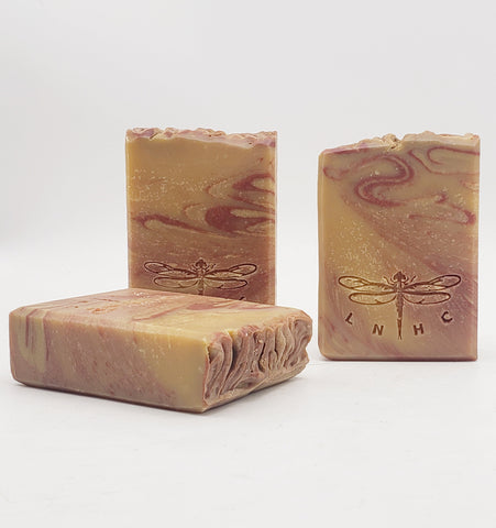 Handmade artisanal soap bars with swirled patterns and dragonfly designs.