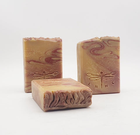 Handmade artisanal soap bars with swirled patterns and dragonfly designs.