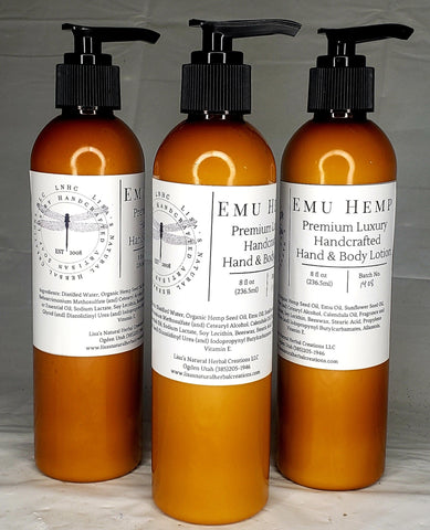 Three amber-colored bottles of EMU Hemp premium luxury hand and body lotion with pump dispensers.