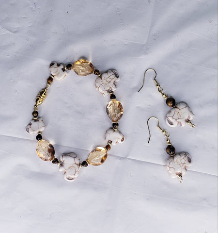 Handcrafted jewelry set featuring white elephant-shaped beads and amber-colored crystal accents.